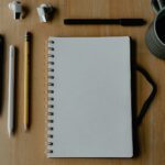 Workspace with notepad, pen, and accessories.